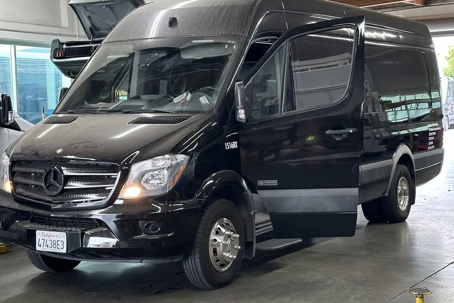 Black Mercedes-Benz Sprinter van in the Umbrella Global Bus shop